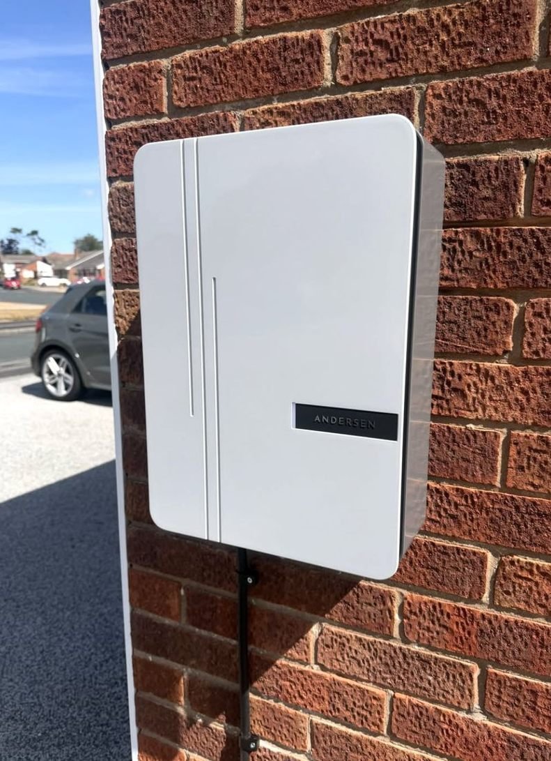 White Andersen EV charger on a brick wall
