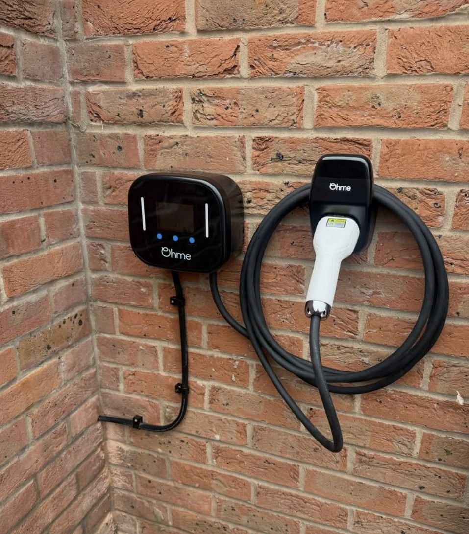 Ohme EV charger on a brick wall