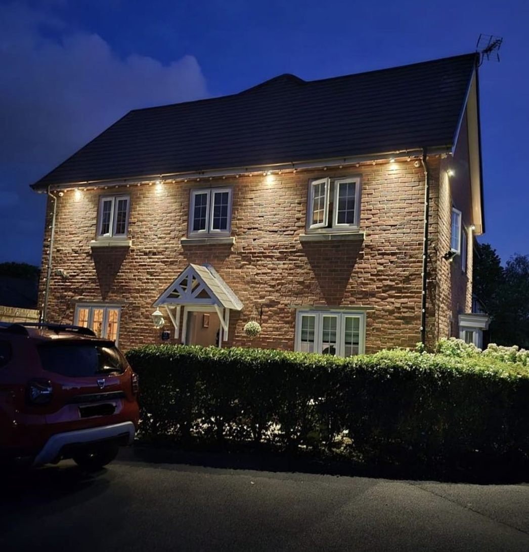 Detached house lit by soffit lights at night